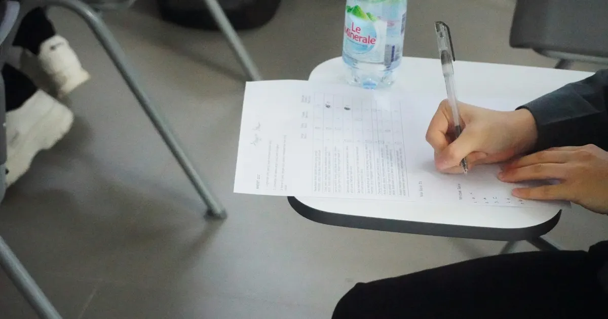 Persona escribiendo a mano en una hoja de examen