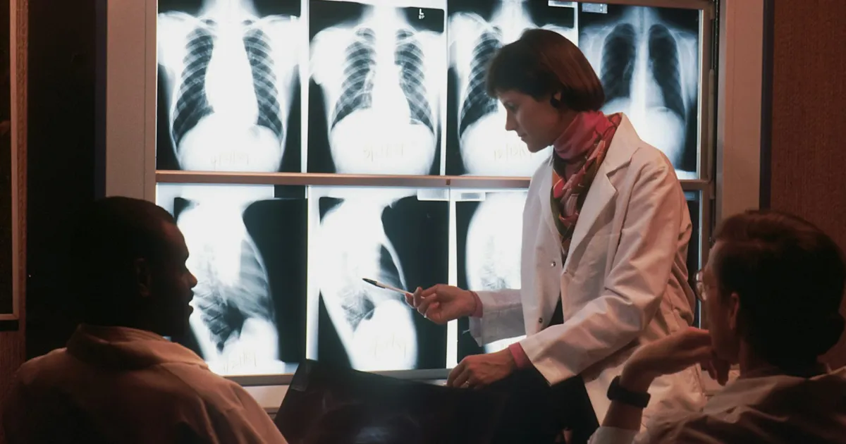 Profesional sanitario revisando una radiografía de tórax con un paciente