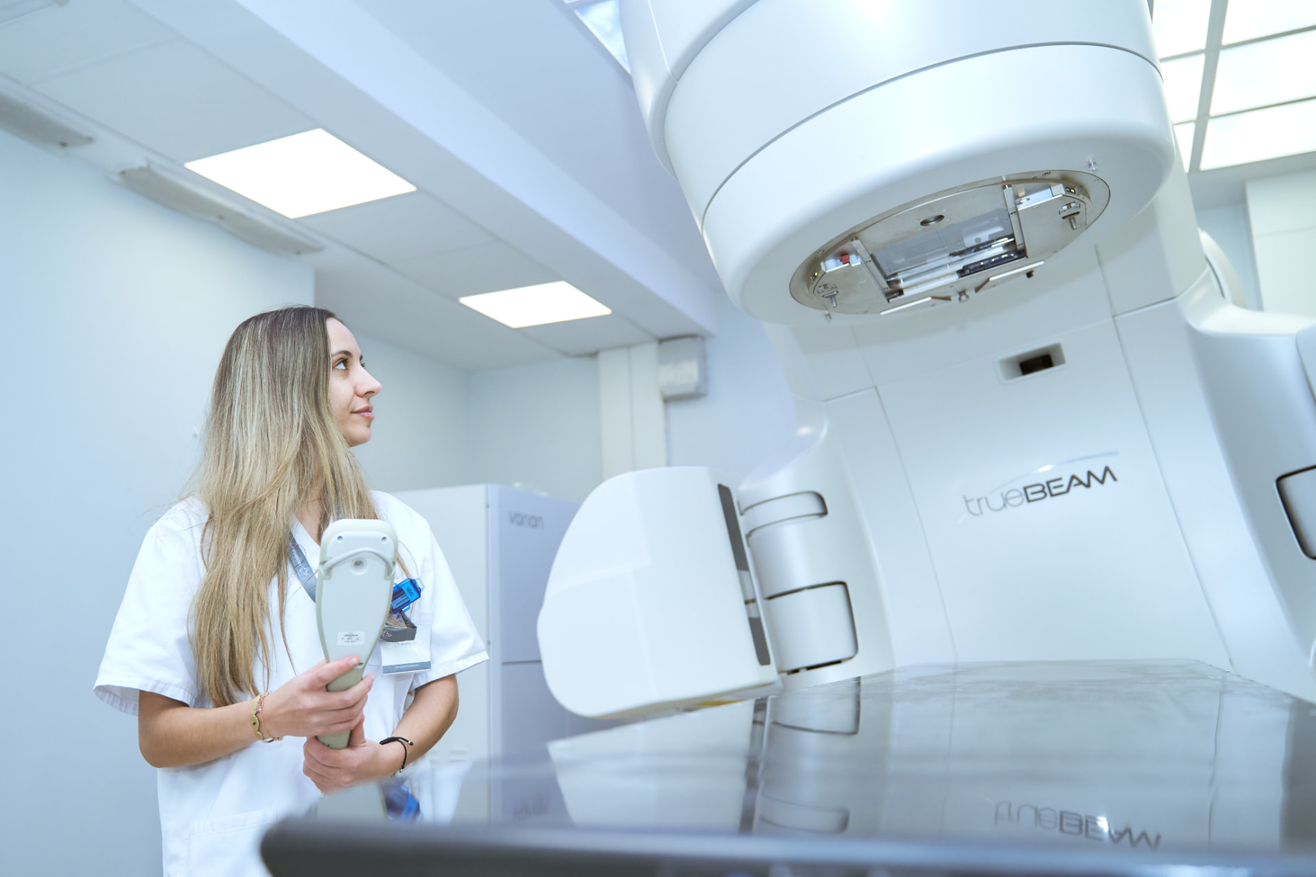 Alumna de Sanitio junto a un acelerador TrueBeam